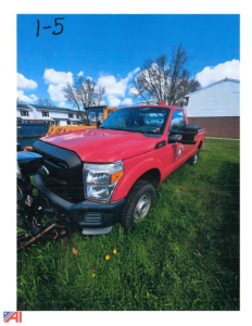 Truck showing red 2011 Ford F-250 Super Duty with plow attachment in front, grassy lot, blue sky.
