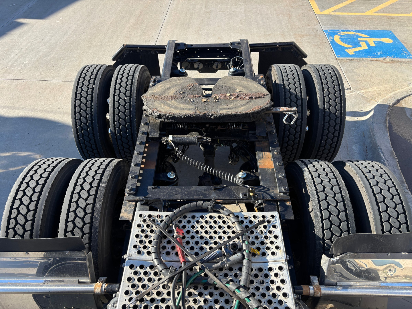 Kenworth T680 chassis view showing rear fifth wheel and dual rear axles with dual tires and exposed metal frame.