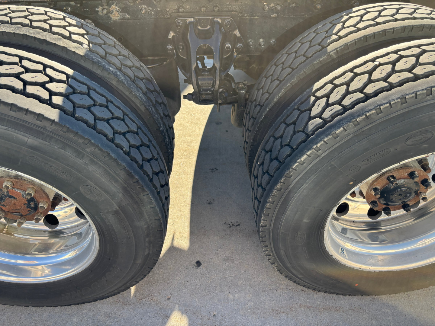 Dual rear wheels/truck tandem showing tires and hub assemblies for a 2022 Kenworth T680 in-wheel area.