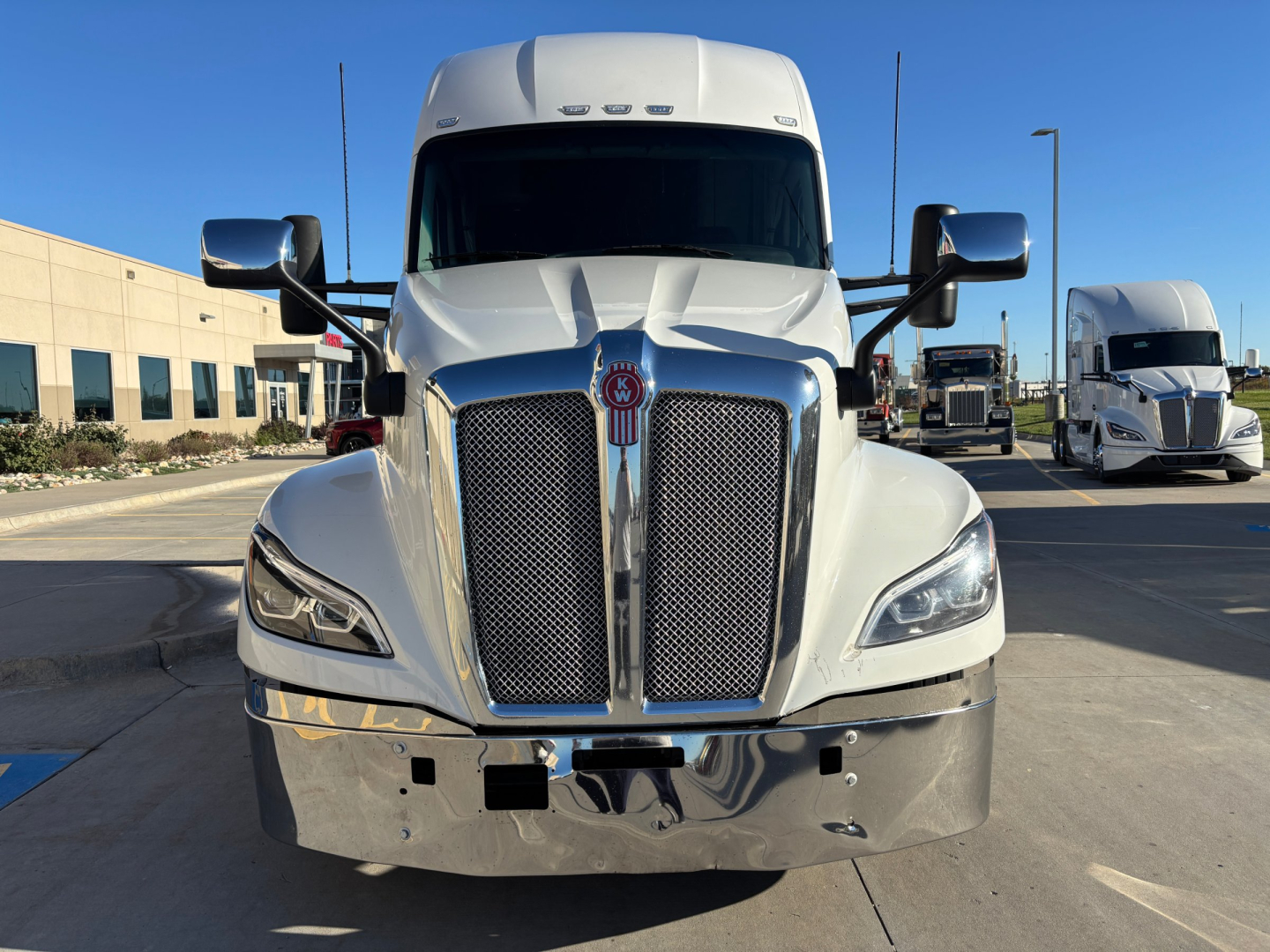 Kenworth T680 front view showing chrome grille, headlights, large bumper, and tall aerodynamic hood with Kenworth emblem.