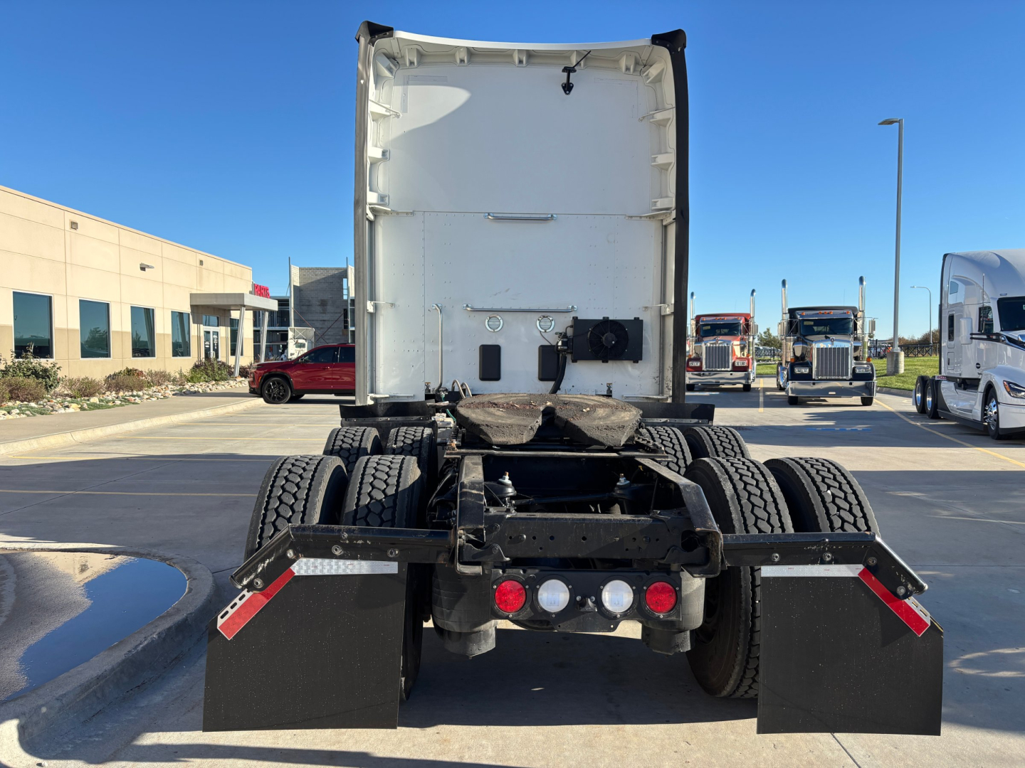 Rear view of a Kenworth T680 tractor with fifth wheel, dual rear axles, and mud flaps. Visible are rear lights, brackets, and clean white cab back, stock number 0635505 label.