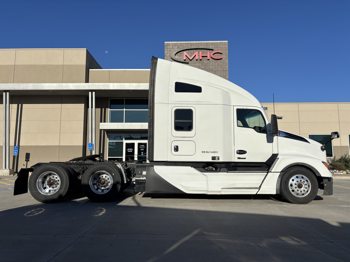 Kenworth T680 tractor in side profile showing sleeper cab and dual rear axles, white paint.
