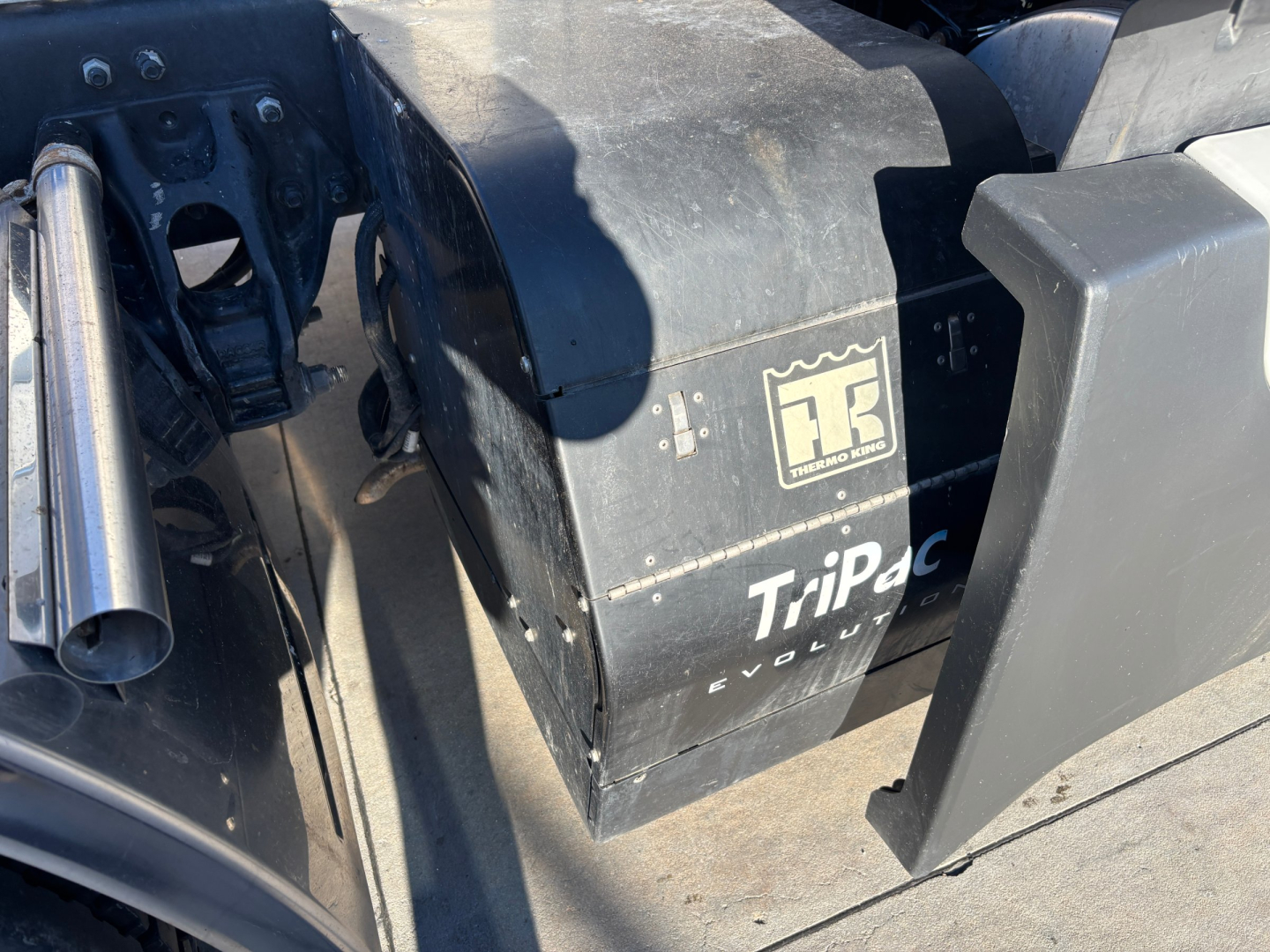 Truck engine bay area showing TriPac Evolution auxiliary heater unit with HR logo, and various metal components.