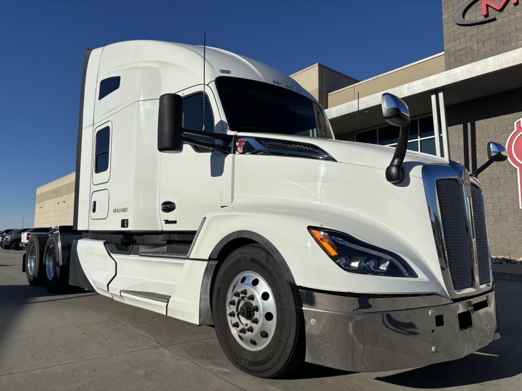 Kenworth T680 tractor-trailer in white, angled view showing cab and front wheel.
