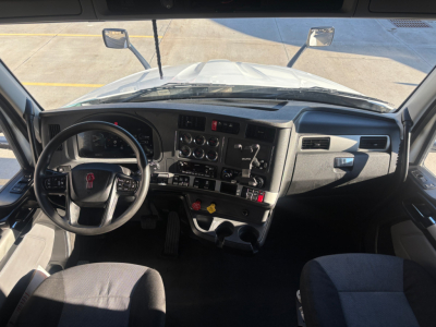 Kenworth T680 cab interior dashboard and steering wheel view from driver's seat, with gauges, controls, and mirrors visible.