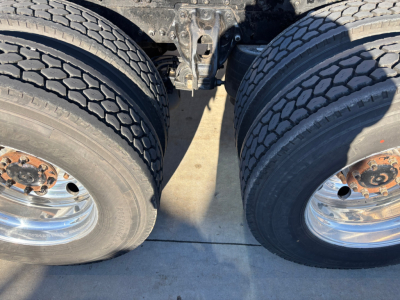 Kenworth T680 truck dual rear wheels showing tires and rim detail, undercarriage visible.