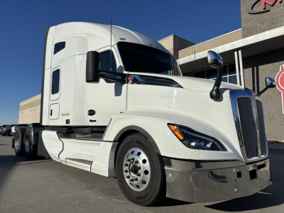 Kenworth T680 tractor-trailer in white, angled view showing cab and front wheel.