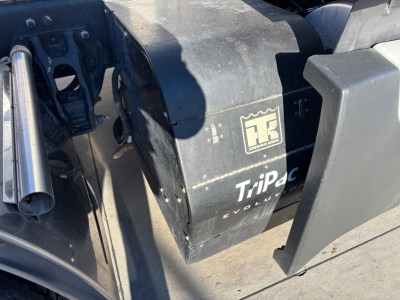 Truck engine bay area showing TriPac Evolution auxiliary heater unit with HR logo, and various metal components.