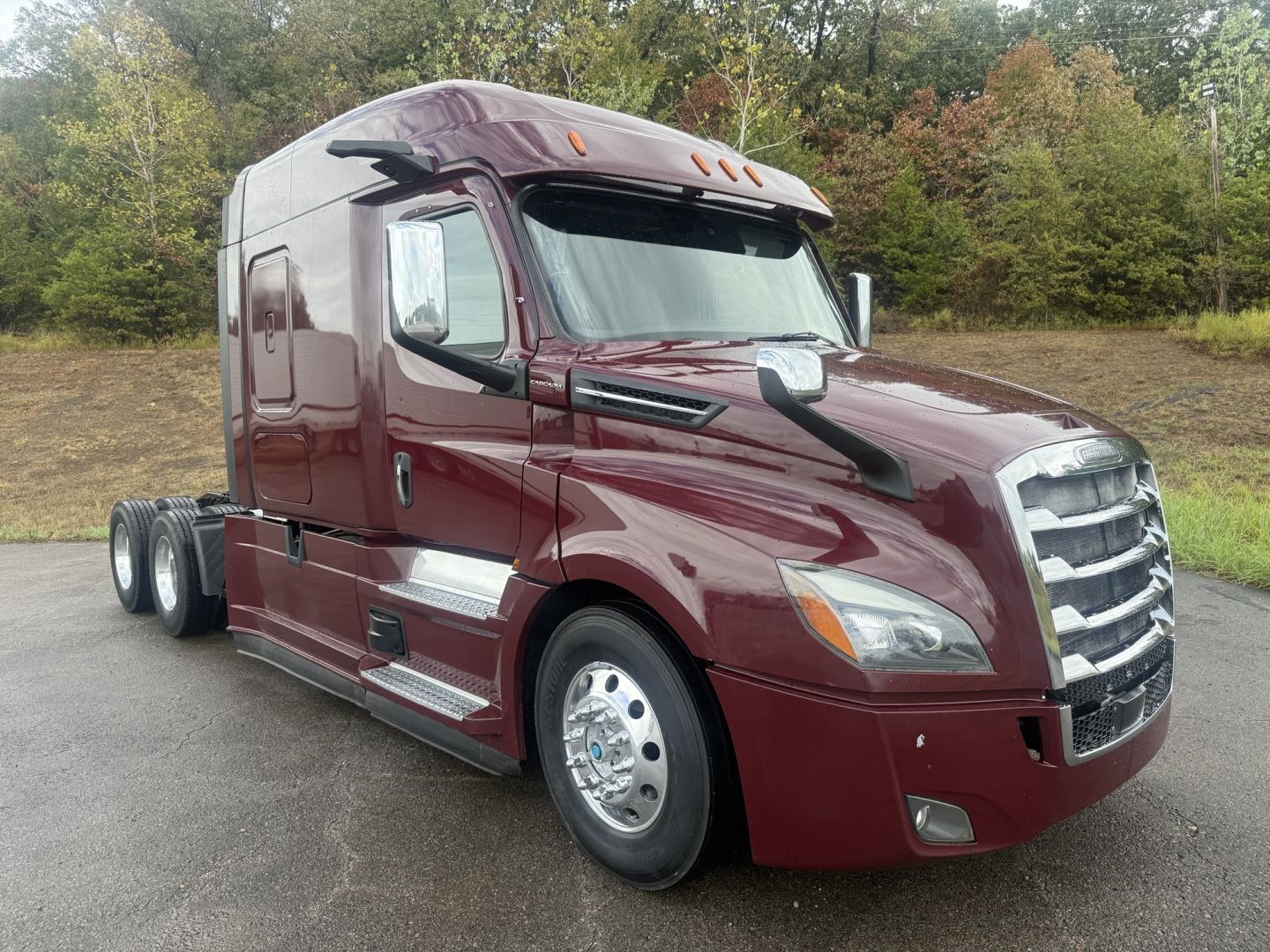 Freightliner Cascadia125/126 sleeper tractor in maroon showing front grille, headlights, mirrors, and dual rear axles.