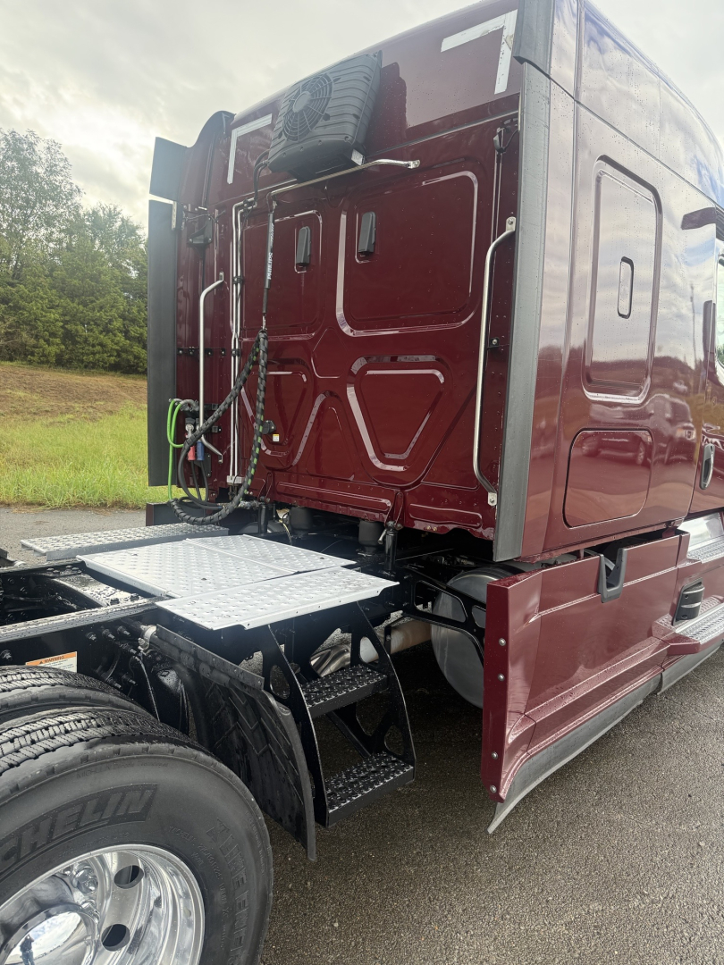 Freightliner Cascadia 126 rear cab view showing sleeper, maroon paint, side steps, and rear mudguard.