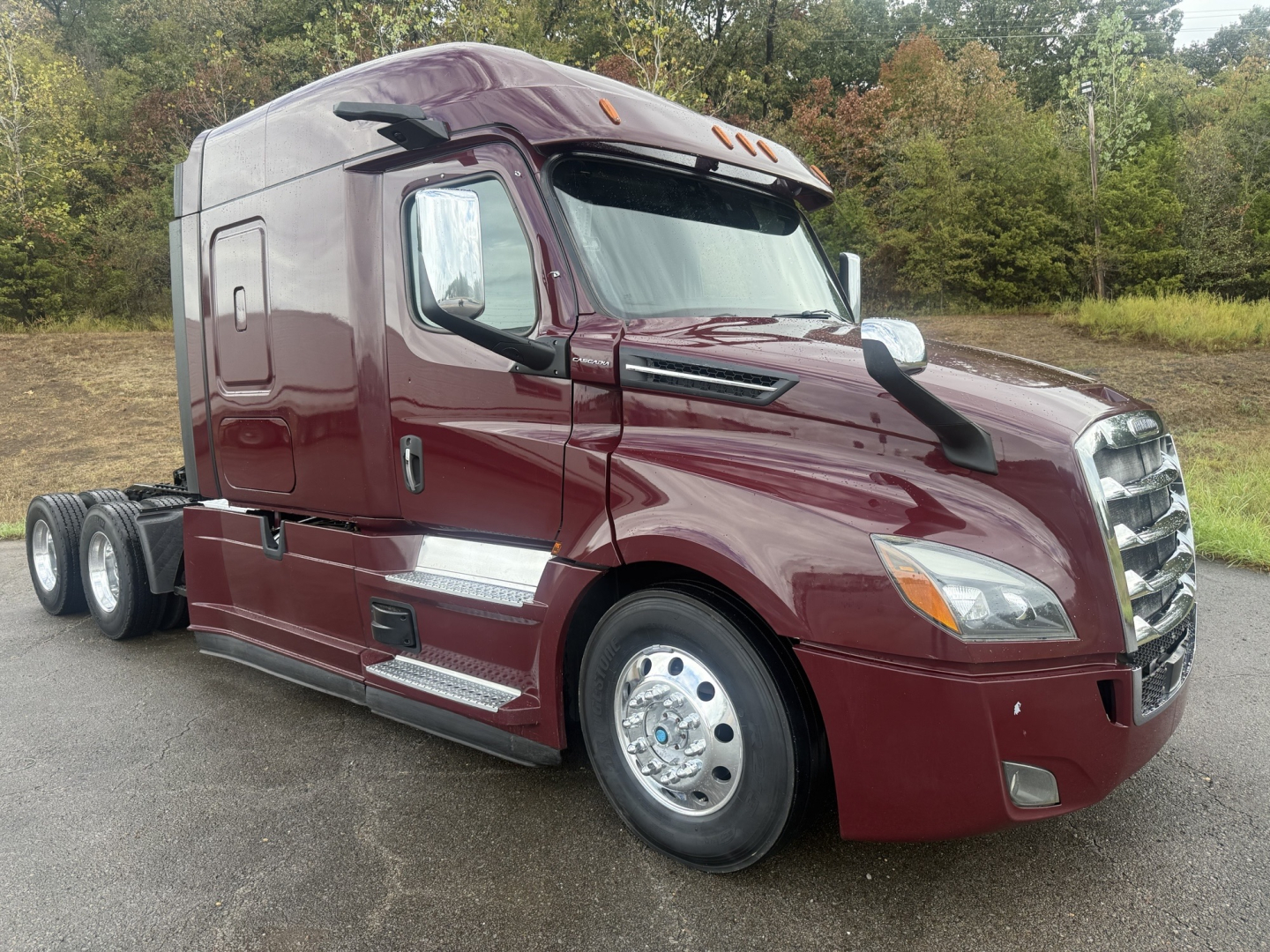 Truck cab showing Freightliner Cascadia 126 with maroon exterior, side chrome steps, dual rear axles, VIN 3AKJHHDV3MSMG5239 visible.