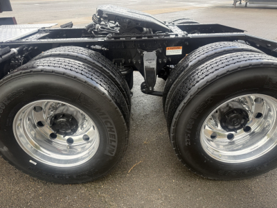 Dual rear axles with chrome wheels and Michelin tires; chassis frame and fifth-wheel area visible; no cargo pictured.