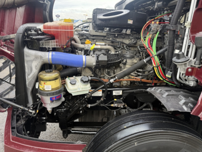 Freightliner Cascadia126 engine bay with coolant reservoir, oil filter, and various colored wiring loom visible.