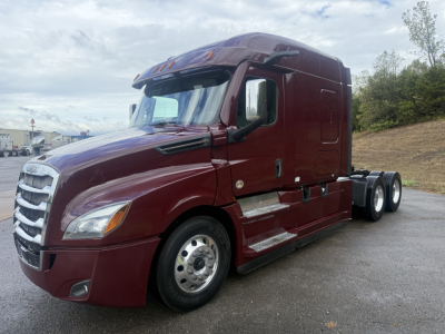 Freightliner Cascadia126 tractor in maroon showing side profile and front grille with sleeper cab and dual rear axles