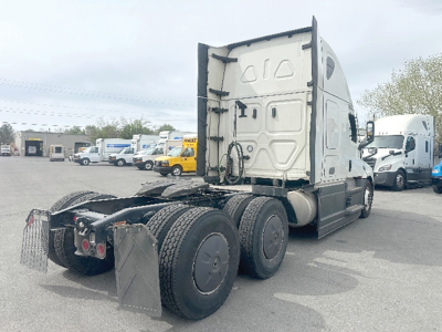 Freightliner Cascadia126 tractor cab and rear wheels in a truck lot showing sleeper cab and chassis. Visible tires and rear mud flaps.