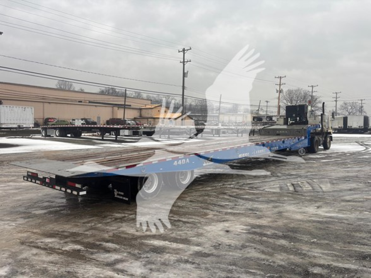 2016 Landoll 440B traveling axle trailer showing long flatbed with blue deck and rear ramps
