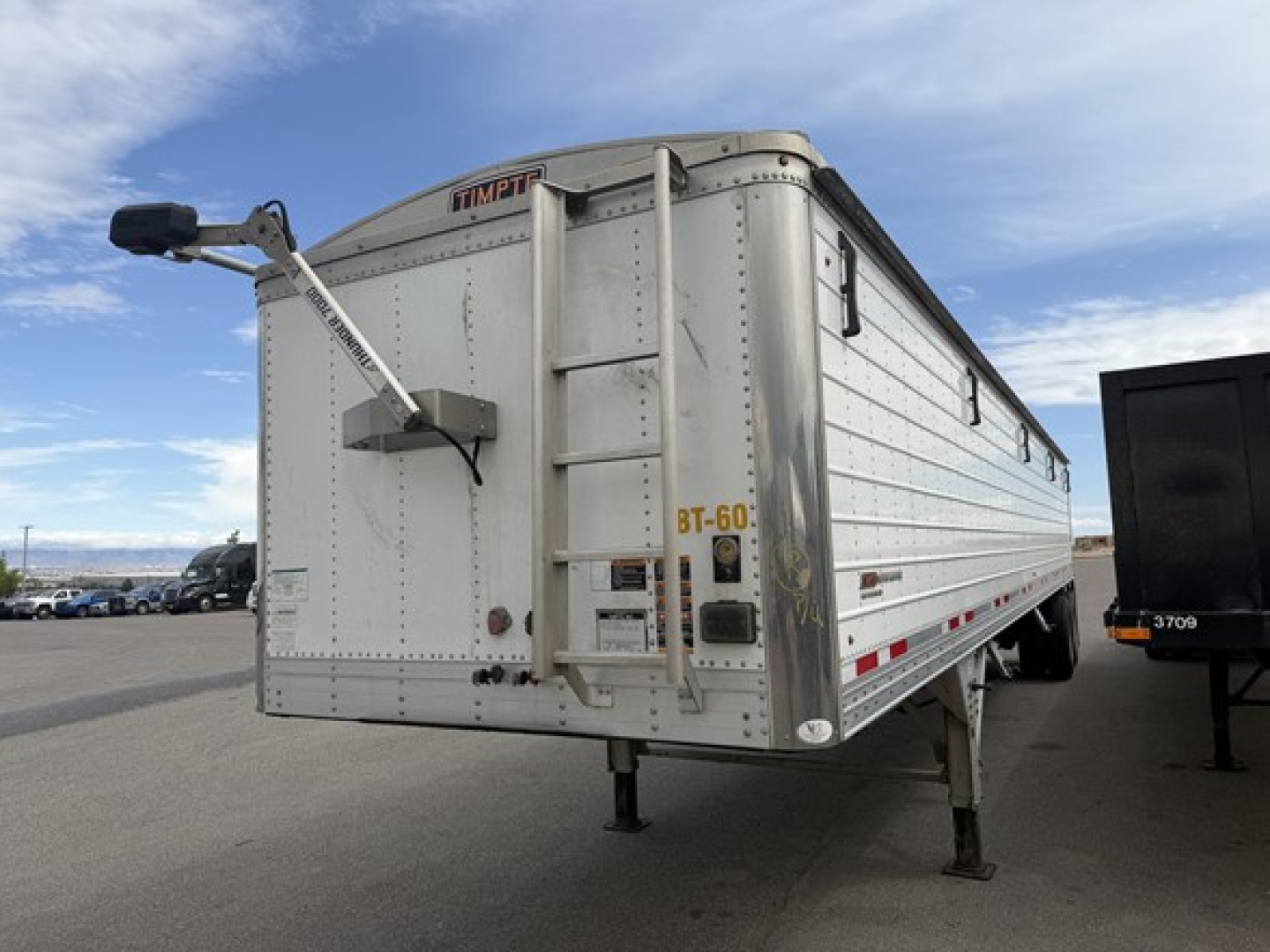 Timpte hopper trailer rear-left side with BT-60 rear door, ladder, and landing legs visible.