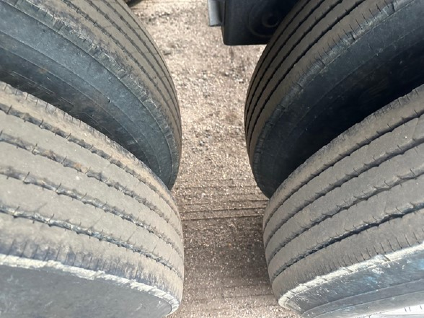Trailer tires in a dual-axle setup with tread lines visible, part of a 2025 CPS 40' light weight air ride bottom dump trailer listing.