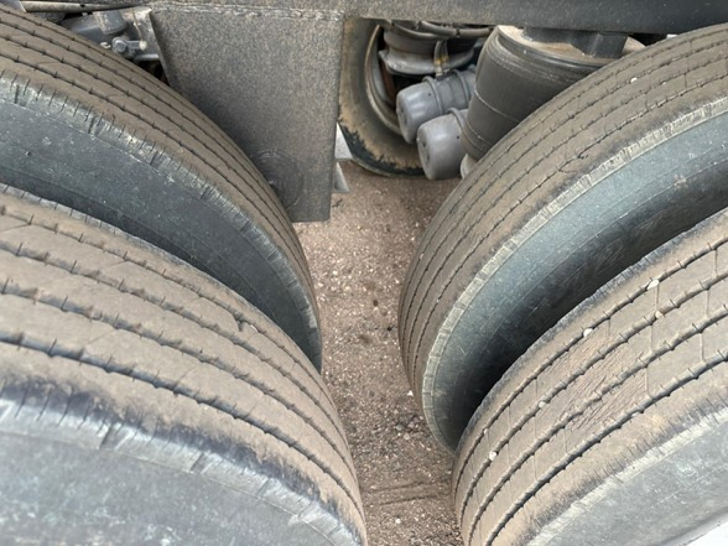 Trailer axle and tires close-up showing dual rear wheels and undercarriage components of a 2025 CPS 40' light weight air ride bottom dump.