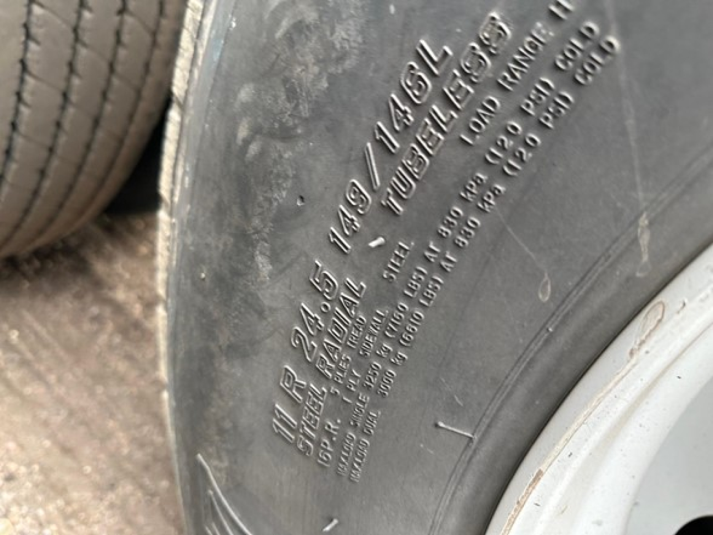 Trailer tire sidewall with embossed markings including 2149 1494 SL, load range and tire specs.