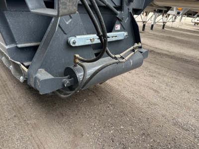 Bottom-dump trailer hitch and rear undercarriage showing hydraulic hoses and frame hardware.