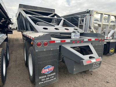 Trailer rear view showing 40' light weight bottom dump with air ride, dual axles, red and white reflective tape, utility logo, Colorado contact on mudguard.