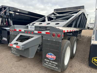 Bottom dump trailer rear and side view showing dual rear axles and Utility logo, with reflective tape and license plate area.