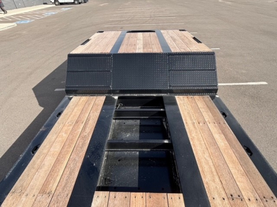 Trailer bed showing dual drop deck with swingouts and wood planks on a lowboy trailer.