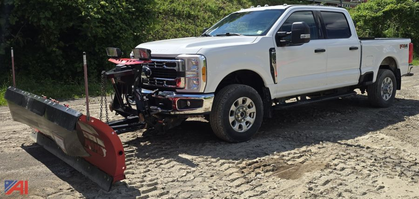 Ford F-350 Super Duty Crew Cab pickup with snow plow attached in a dirt lot.