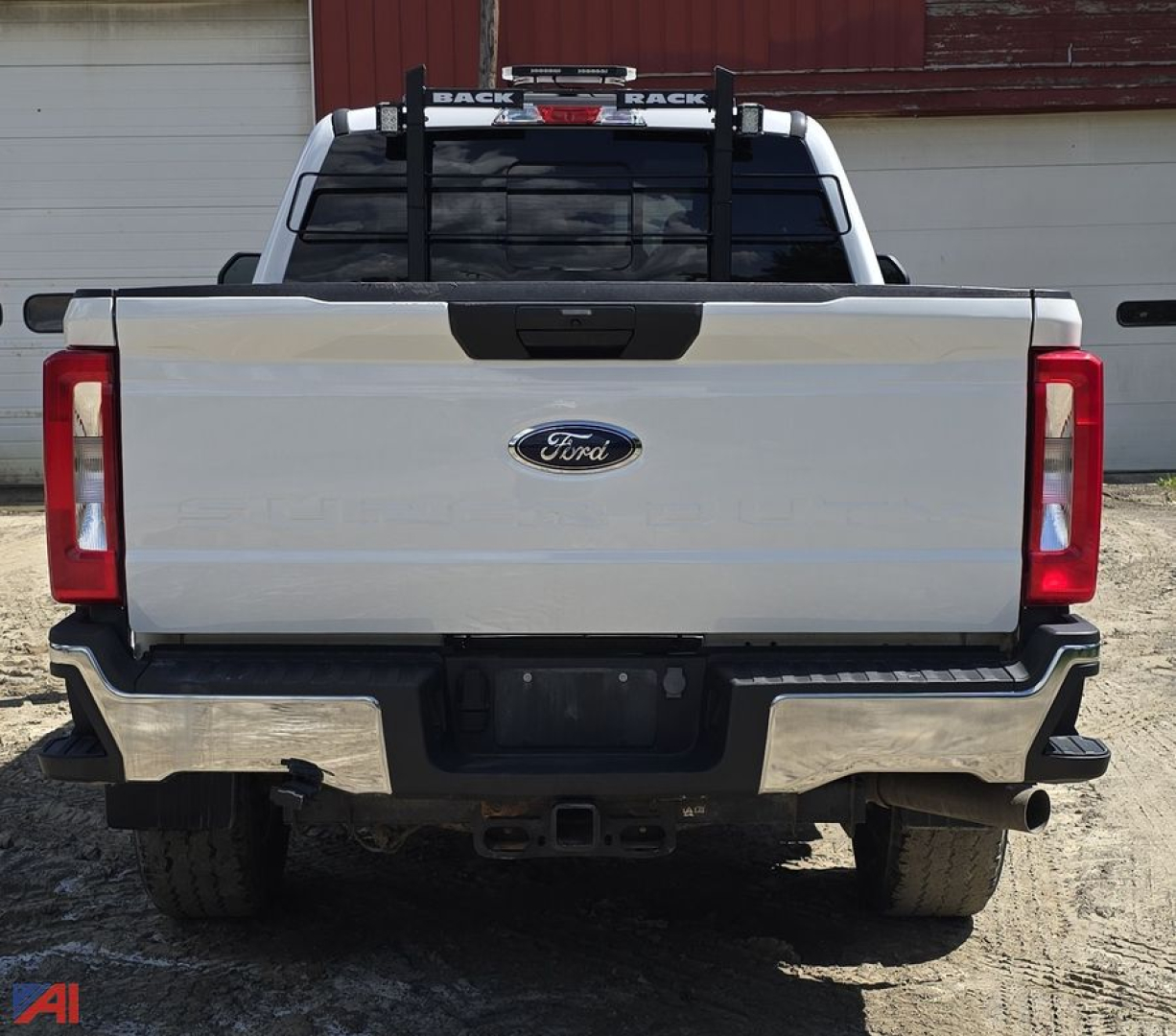 Ford F-350 Super Duty rear view with plow setup and towing hitch, crew cab, white exterior, chrome bumper, taillights visible.