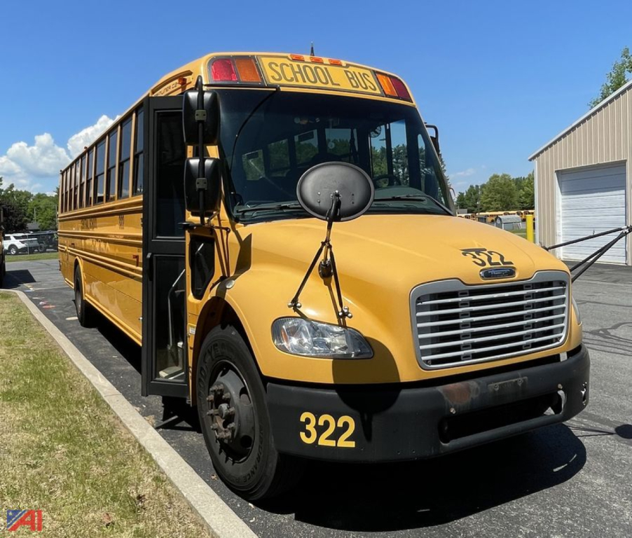 Front-left view of a yellow 2014 Freightliner C2 school bus with 'SCHOOL BUS' sign, black bumper, large circular side mirror, and number 322 on the front fender.