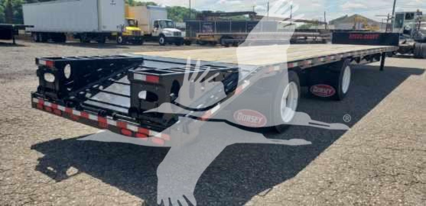 Dorsey dropdeck trailer parked in lot showing rear and side rails, black paint with red and white reflective strips, Dorsey logo on wheel fenders.