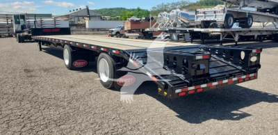 Trailer: Dorsey dropdeck flatbed with black frame and dual rear wheels, reflective tape, and rear light bar; visible decals show 'Dorsey' on mudflaps.
