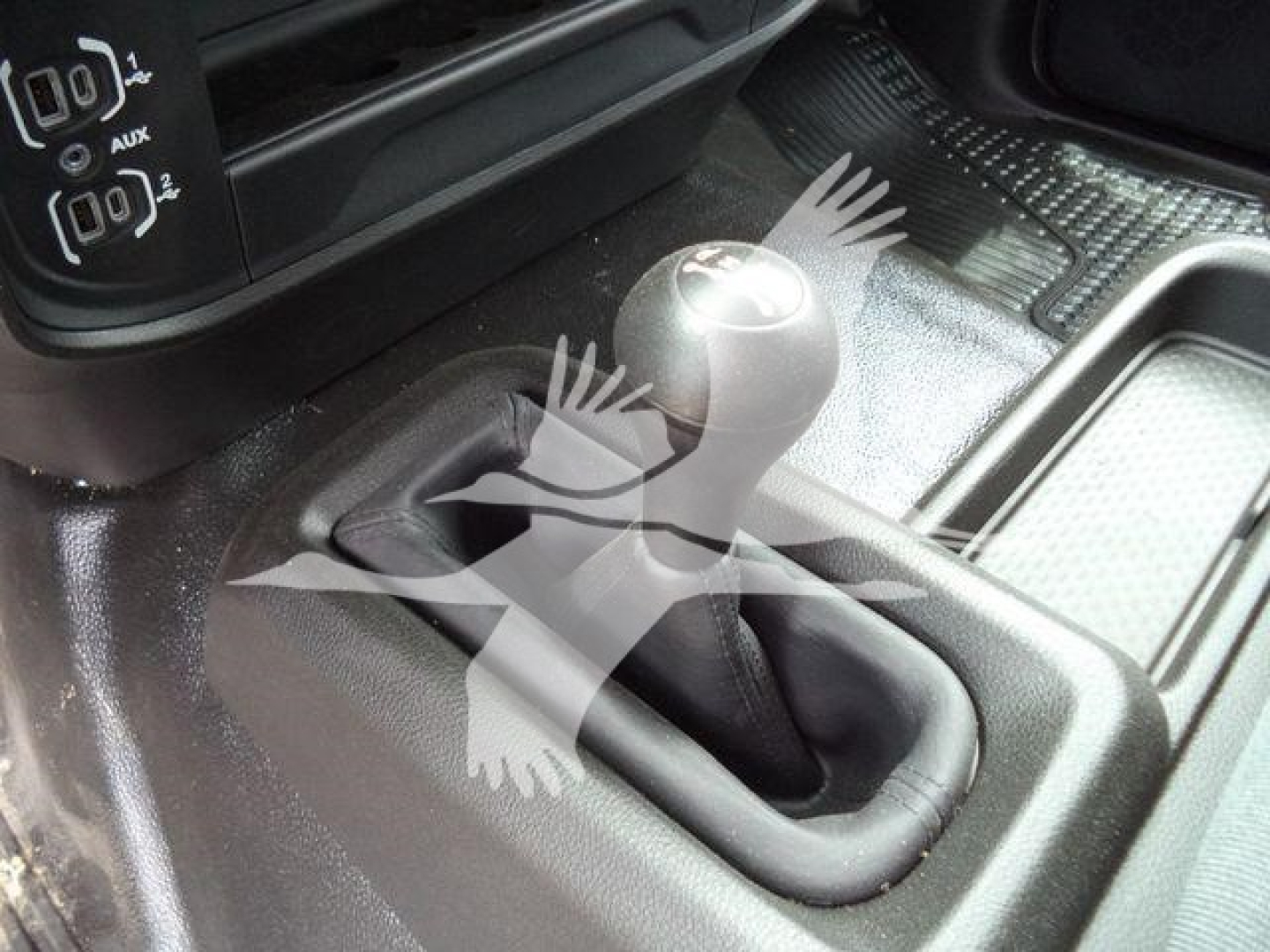 Ram 4500 interior showing manual shifter gear lever and center console with rubber boot and textured floor mat.