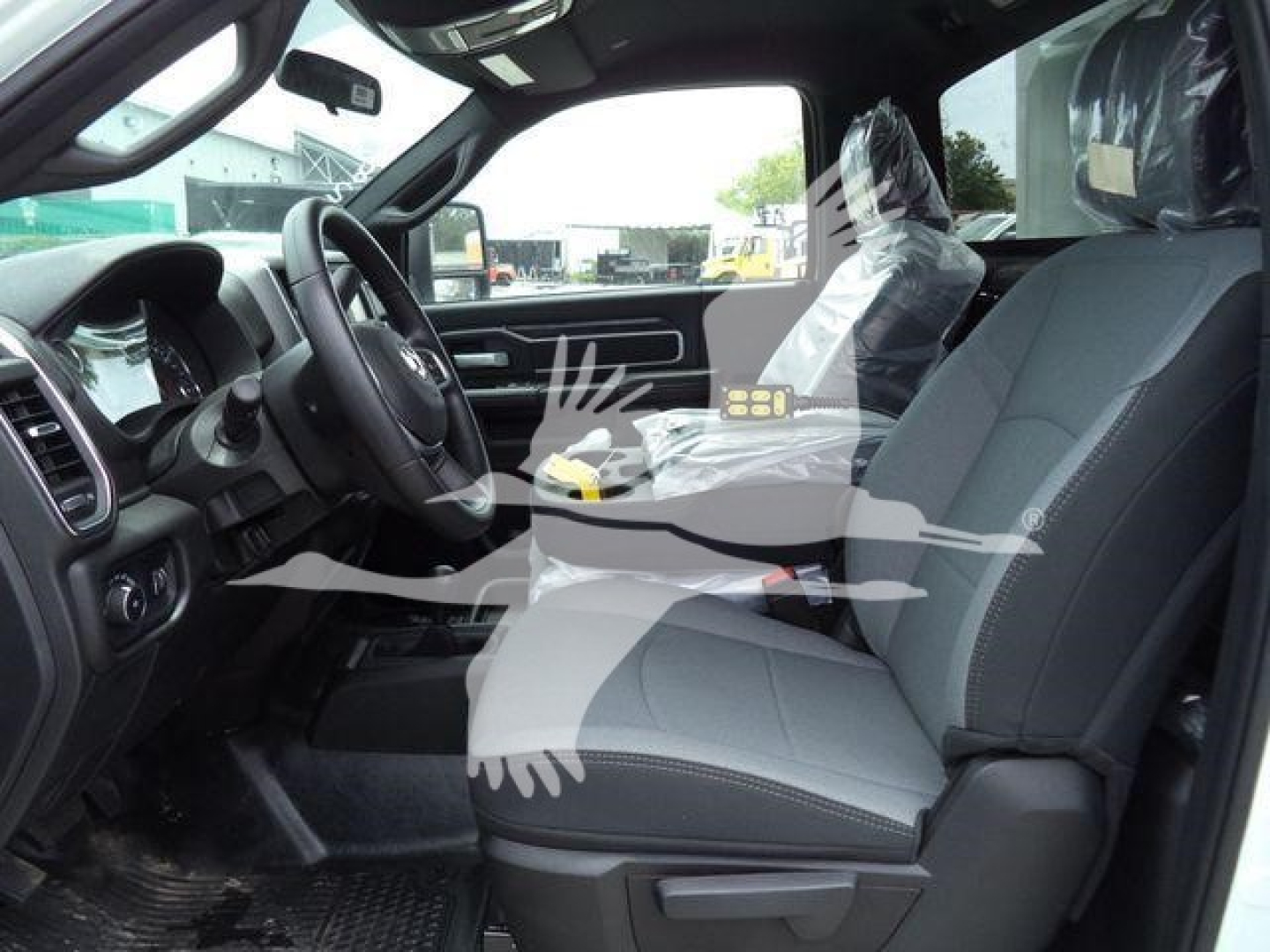 Ram 4500 SLT pickup interior view showing front seats, steering wheel, dashboard, and driver-side door with protective plastic on seats.
