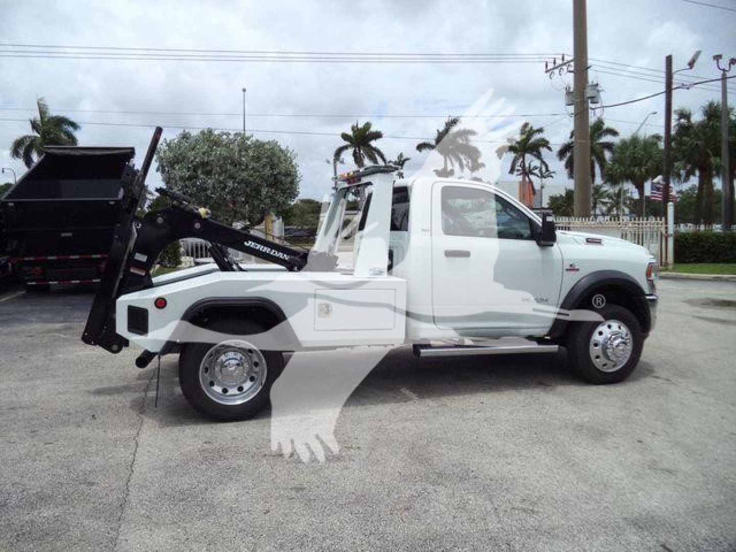 Ram 4500 SLT tow truck with front cab, white body, rear hydraulic tow arm extended, winch equipment, side view showing wheel wells and mirror.