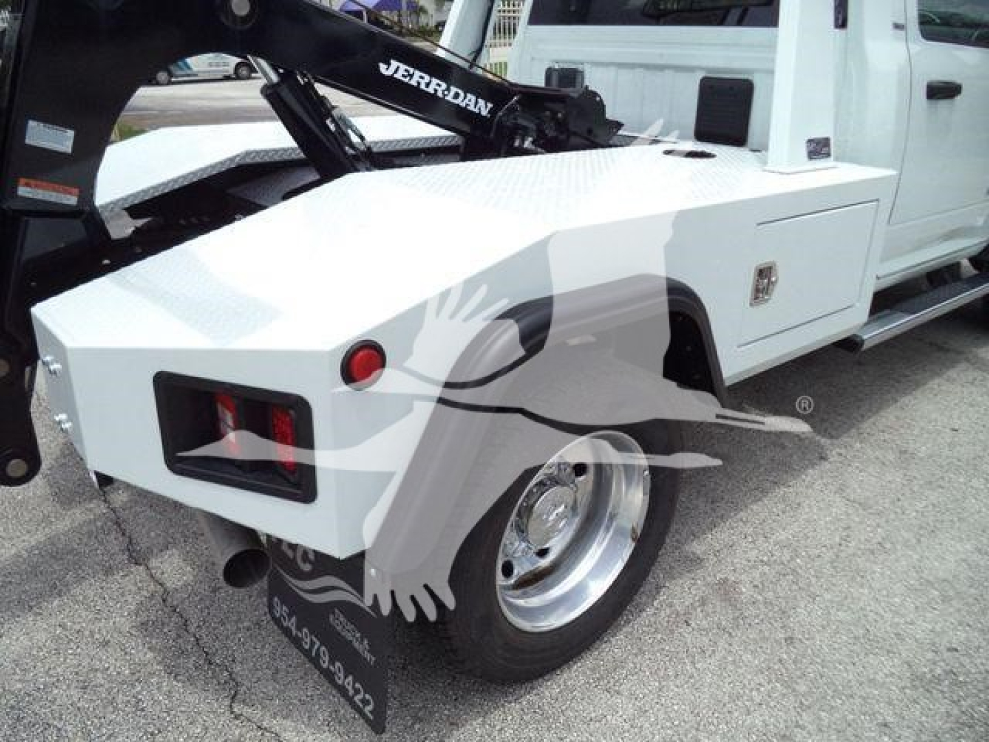 Ram 4500 tow truck bed with winch equipment and white cab; rear wheel and fender visible