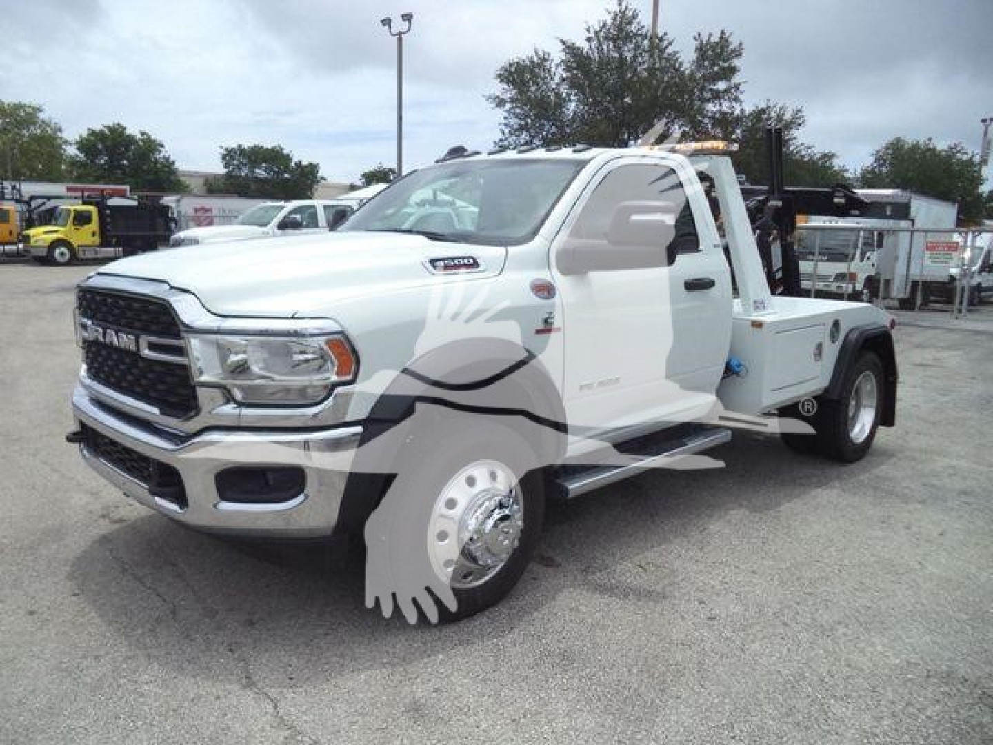 Ram 4500 tow truck in white with chrome grille and large front bumper; tow winch equipment mounted in bed; F-Cab mirror, dual rear wheels visible; RAM emblem on grille