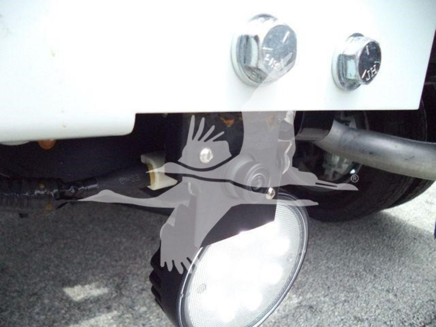 Ram 4500 winch truck front bumper with large round light and tow hooks visible; close-up of front bumper area and wiring.