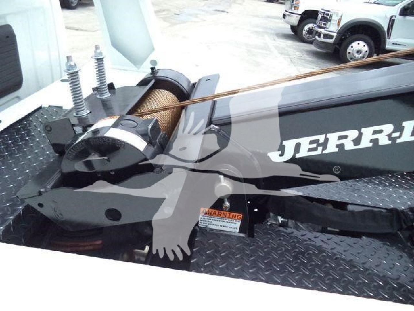 Winch system mounted on truck bed with Jerry? brand visible on side, rope spool and winch housing, winch mounting plate.