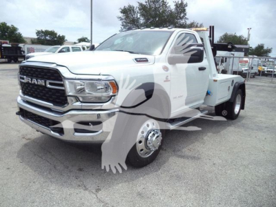 Ram 4500 SLT dump tow truck in white, front three-quarter view, showing heavy-duty front grille, dual rear wheels, tow winch setup, and side mirrors.