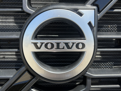 Volvo emblem on truck grille showing circular Volvo crest with chrome ring and black grille bars.