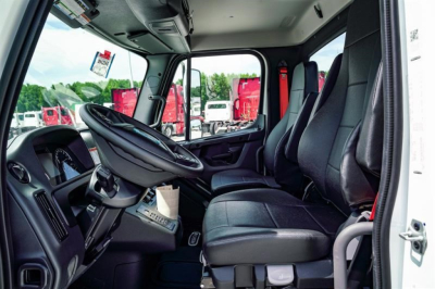 Cab interior of a Freightliner Business Class M2 106 Plus showing seats, steering wheel, and dashboard in view