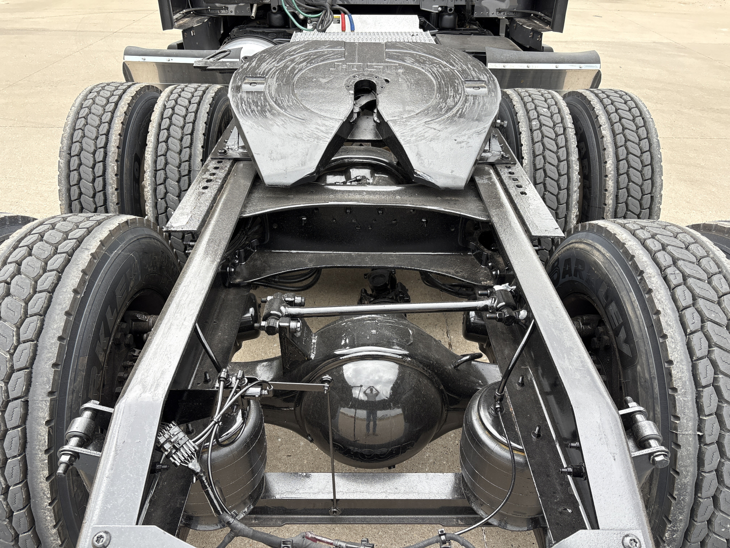 Peterbilt 579 chassis with rear drive axles and suspensions visible; dual rear axles, differential housing, air lines, and leaf spring components seen from rear viewpoint.
