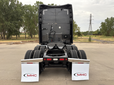 Peterbilt 579 tractor rear view showing rear mud flaps with MHC logo and dual rear wheels.