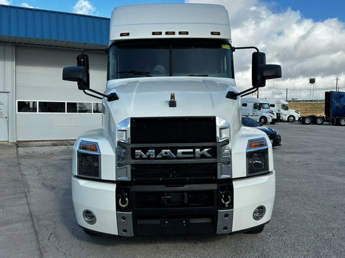 Front view of a white 2020 Mack AN64T70 conventional sleeper truck showing Mack emblem, large grille, headlights, and bumper.