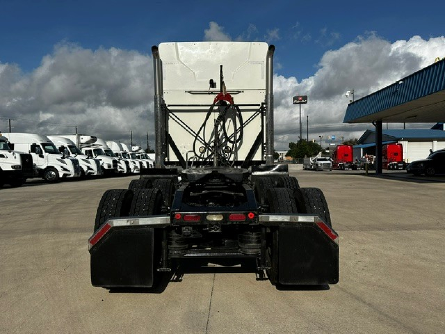 Rear view of a 2020 Mack AN64T70 tractor with fifth-wheel and dual rear axles, chassis, air lines, and mud flaps visible.