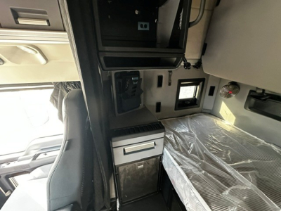 Truck cab interior showing sleeper area and storage compartments.