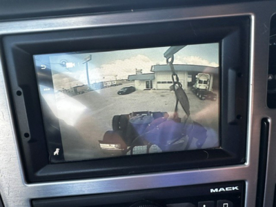 Mack AN64T70 sleeper truck interior display showing a rearview camera feed of a parking lot and trailer in view.