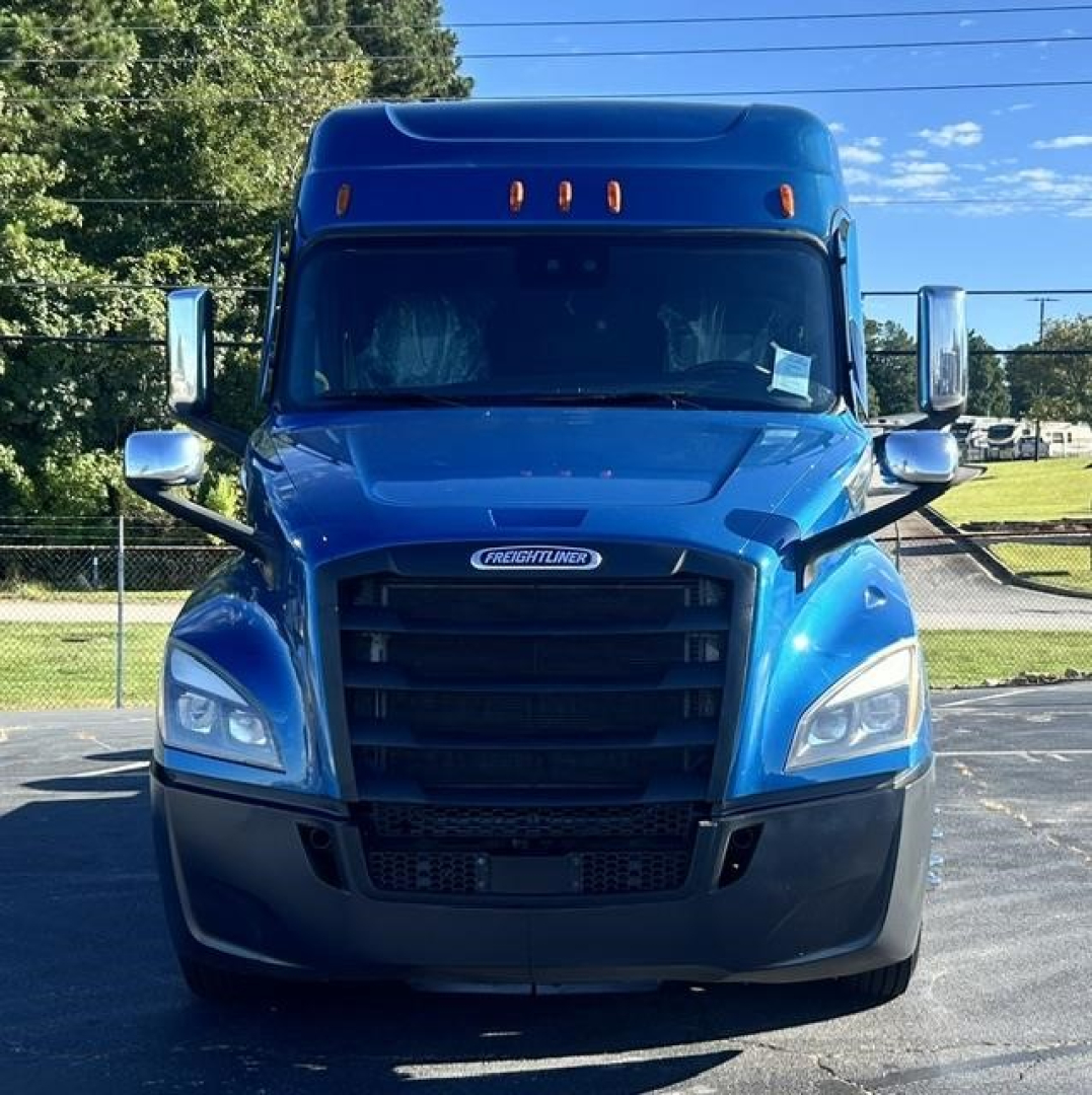 Blue Freightliner Cascadia truck front view showing grille, headlights, side mirrors, and hood with Freightliner emblem.